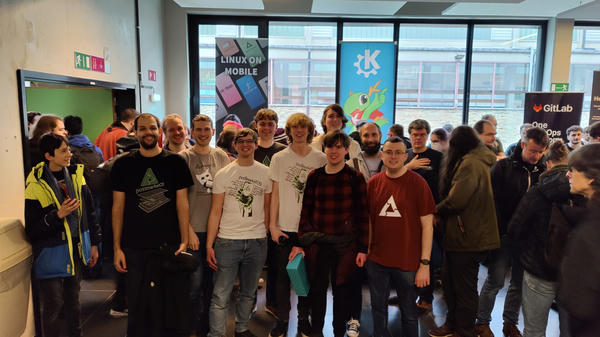 most of the postmarketOS team in front of the Linux Mobile stand
